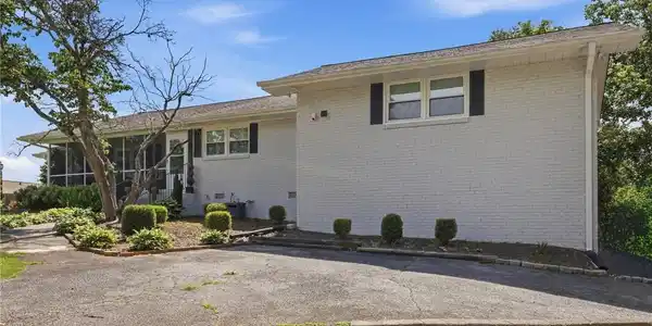 Image 2: A classic brick exterior, screened porch, and verd