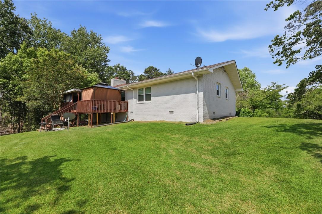 Image 3: A spacious backyard with a raised deck provides am