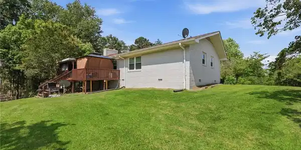 Image 3: A spacious backyard with a raised deck provides am