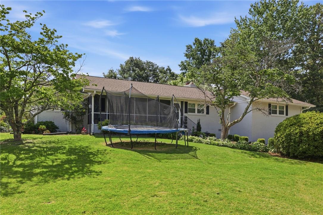Image 4: Mature trees frame a charming home with well-kept