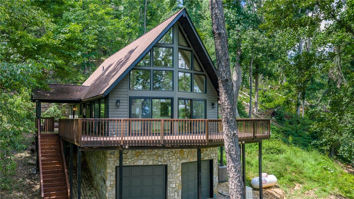 Image 1: An impressive A-frame cabin, nestled among dense t