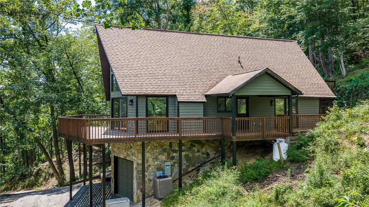 Image 2: Perched among verdant trees, this unique A-frame r