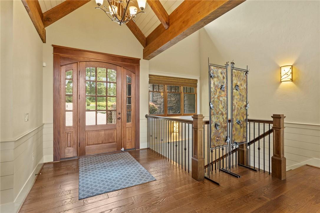 Image 3: A grand entryway welcomes guests with rich hardwoo