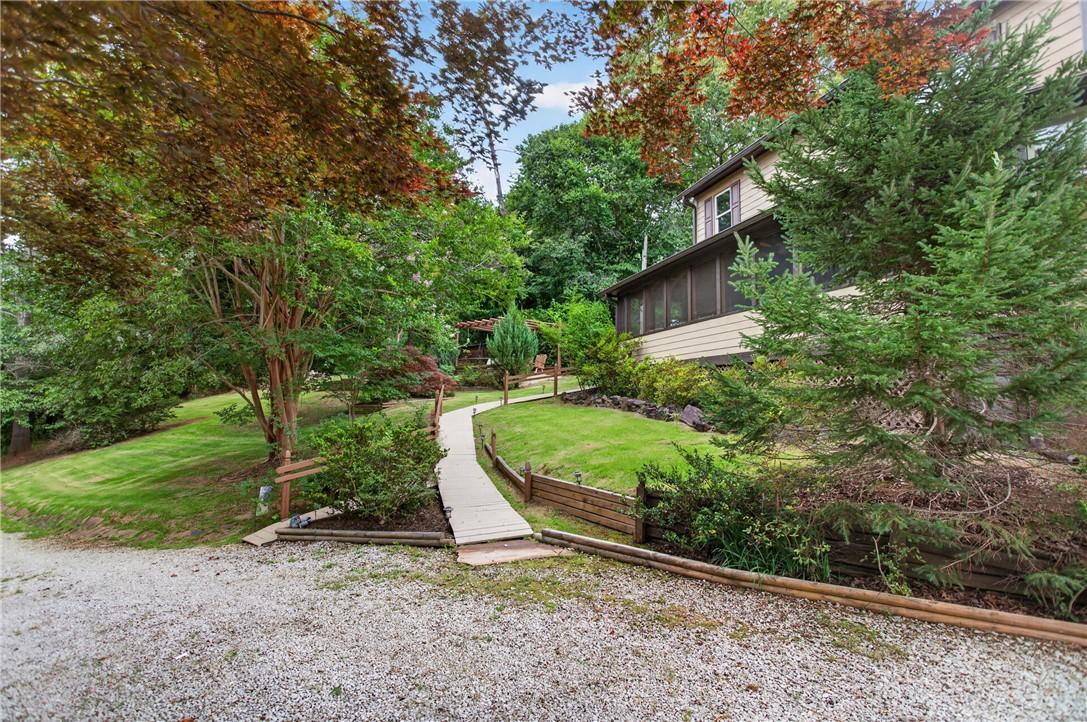Image 3: A winding pathway leads through lush greenery to a