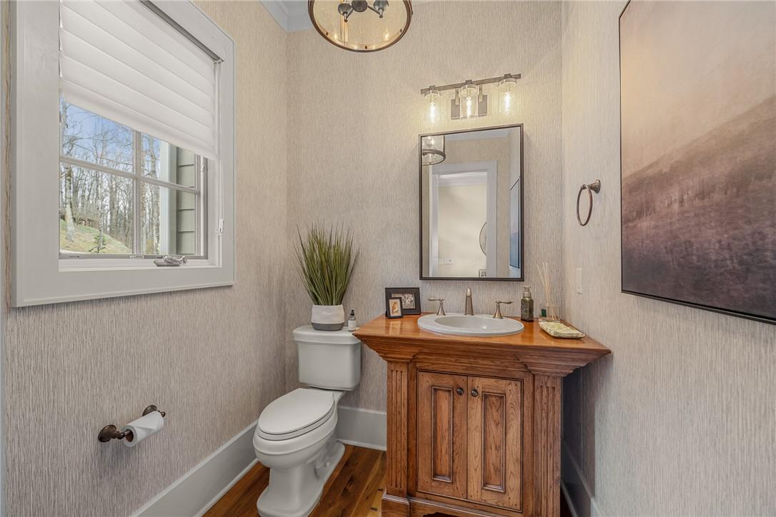 Image 4: This bathroom features hardwood flooring and a sty