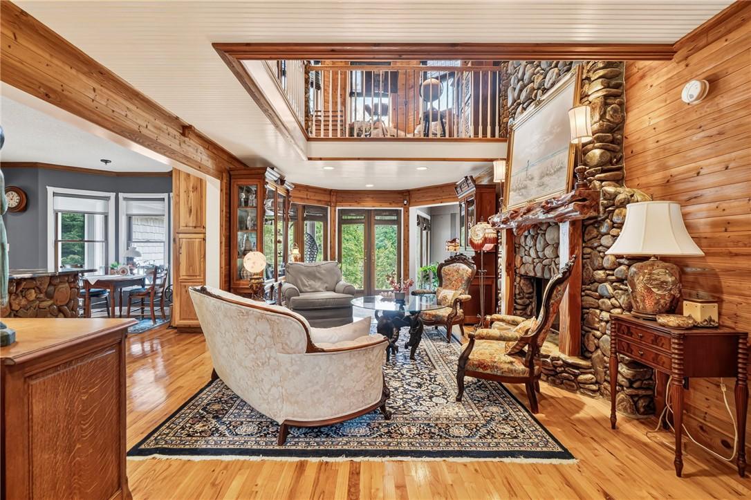 Image 3: A spacious living area features rich hardwood floo