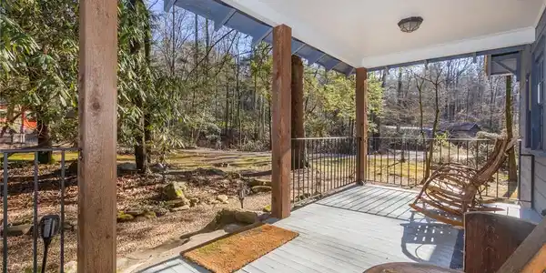 Image 3: A spacious covered front porch overlooks a serene