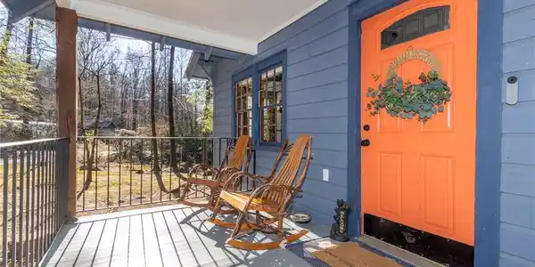Image 4: A welcoming covered porch with wood flooring overl