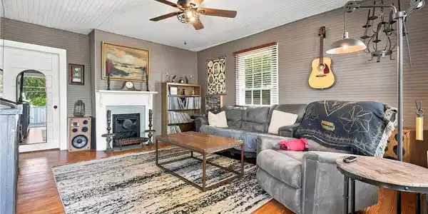 Image 3: Rich wood floors and a decorative fireplace anchor