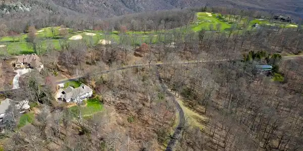 Image 4: An aerial panorama reveals a vast, wooded property