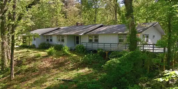 Image 3: This private, wooded retreat features a spacious d