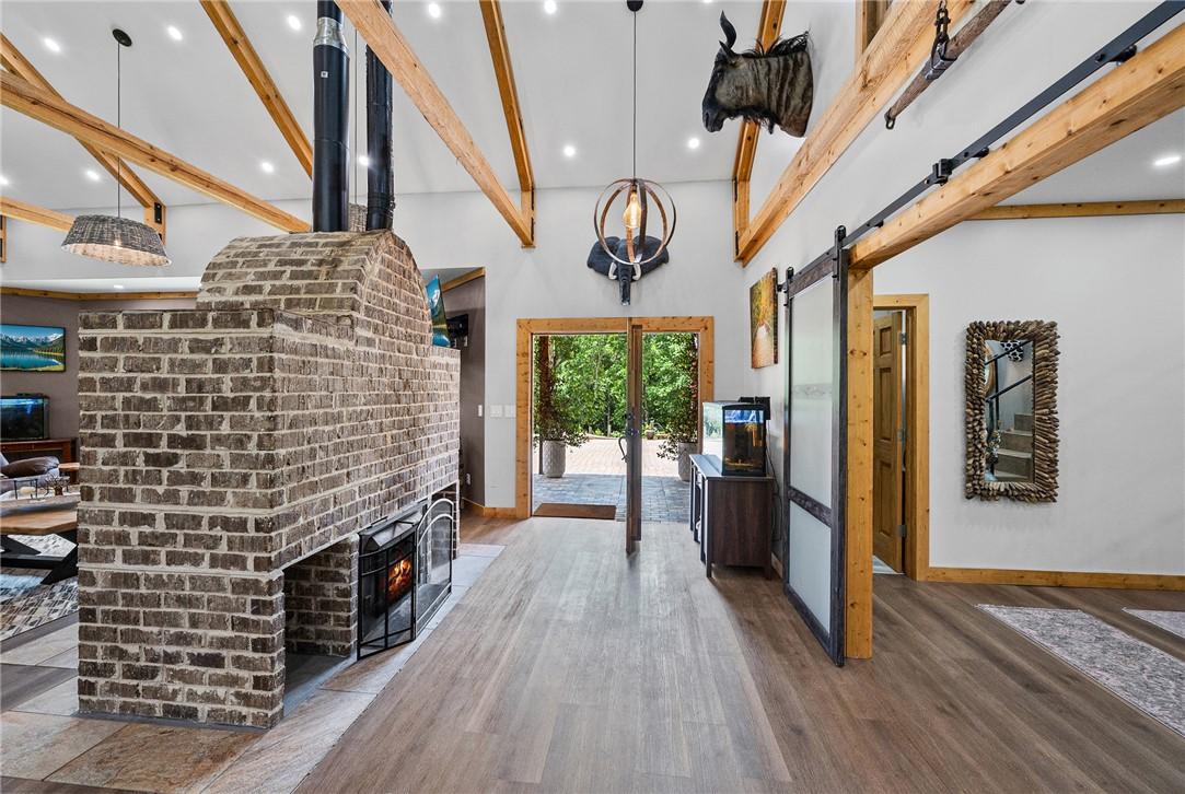 Image 3: A spacious entry showcases exposed wood beams, a s