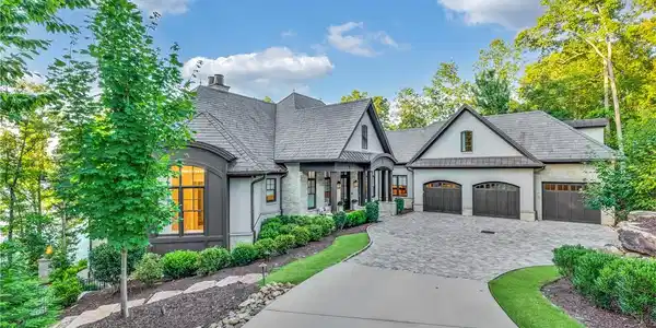 Image 2: A grand estate with a sweeping paved driveway, lus