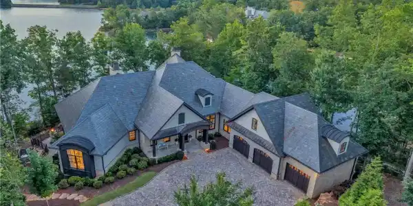 Image 4: A grand lakeside estate with extensive rooflines a