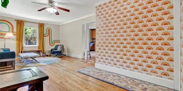 Image 4: Bright and airy living area featuring warm hardwoo