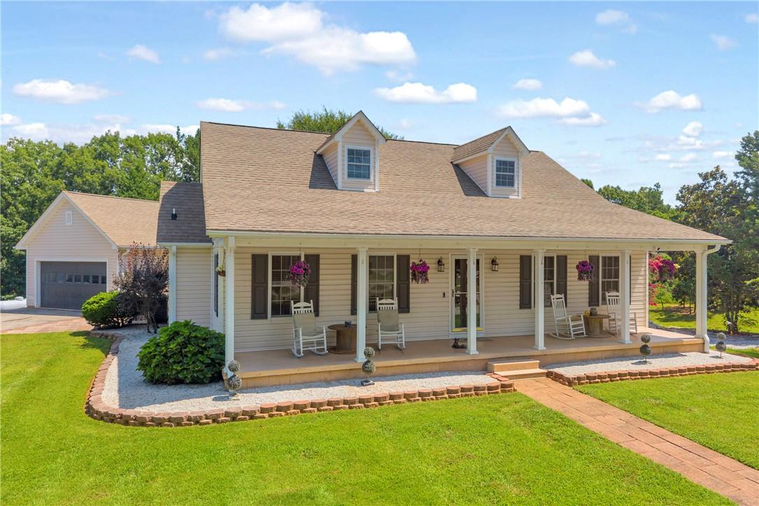 Image 1: A classic Cape Cod style home featuring a covered