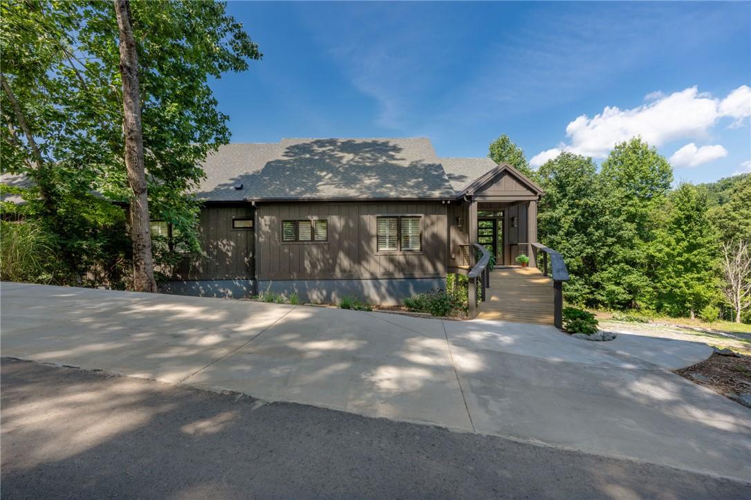 Image 2: A long paved driveway leads to a modern home nestl
