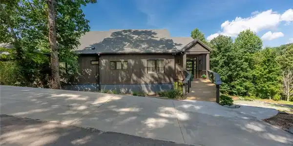 Image 2: A long paved driveway leads to a modern home nestl
