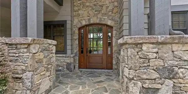 Image 2: A robust stone and timber entrance leads to a soli
