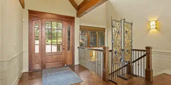 Image 3: A grand entryway welcomes guests with rich hardwoo