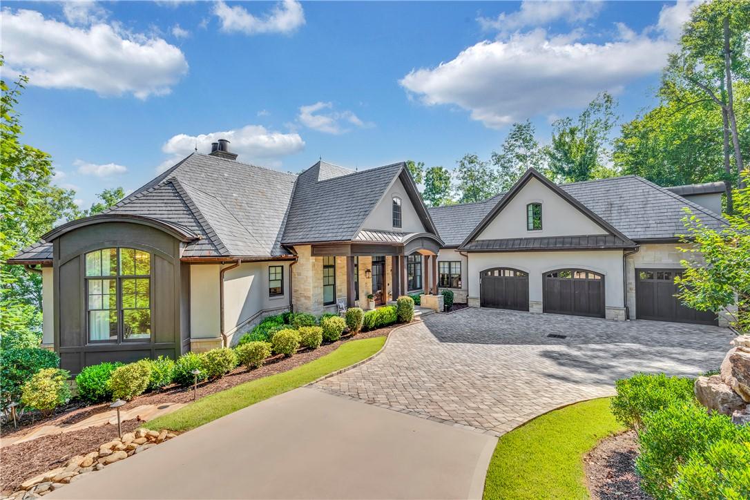 Image 1: Grand estate entry with a paved circular driveway,