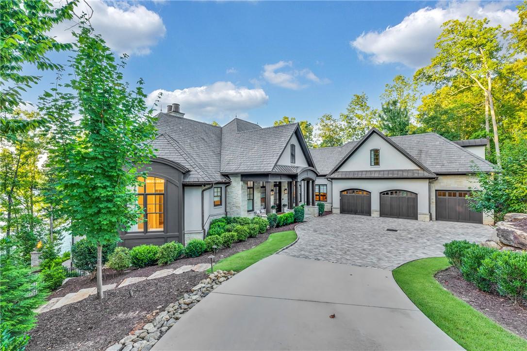 Image 2: A grand estate with a sweeping paved driveway, lus
