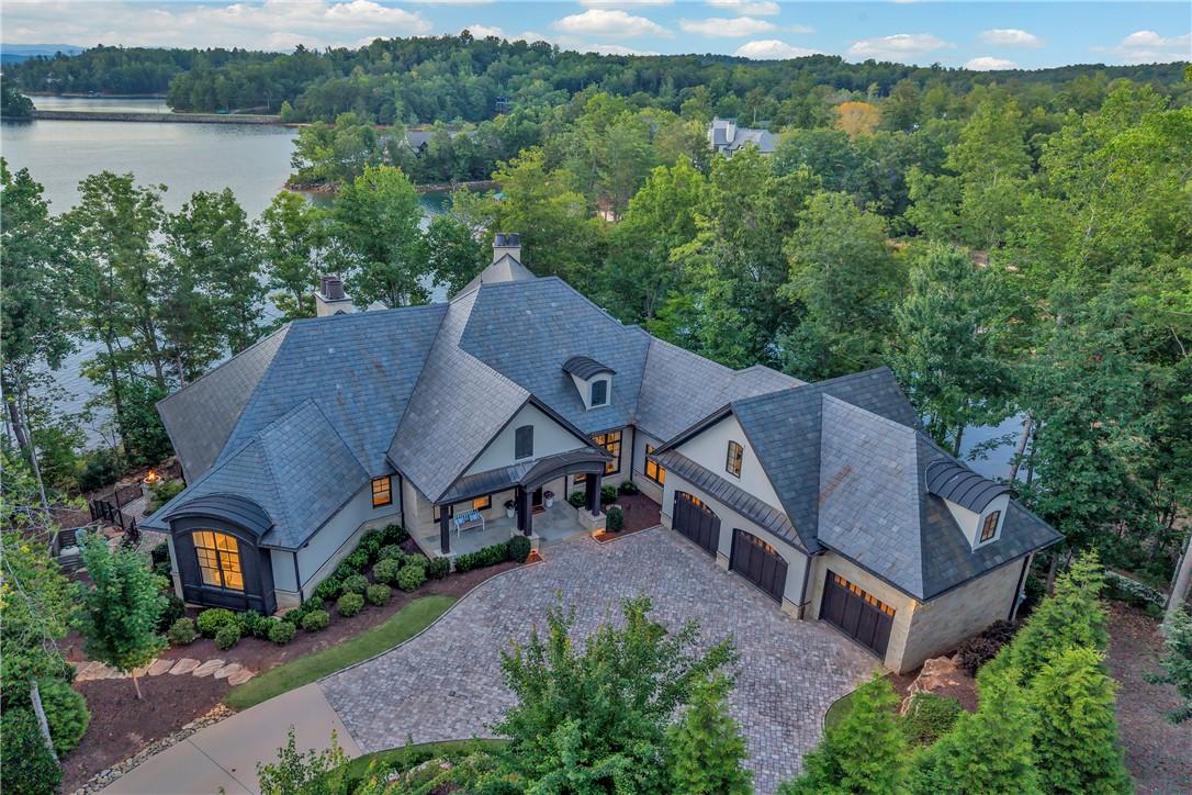 Image 4: A grand lakeside estate with extensive rooflines a
