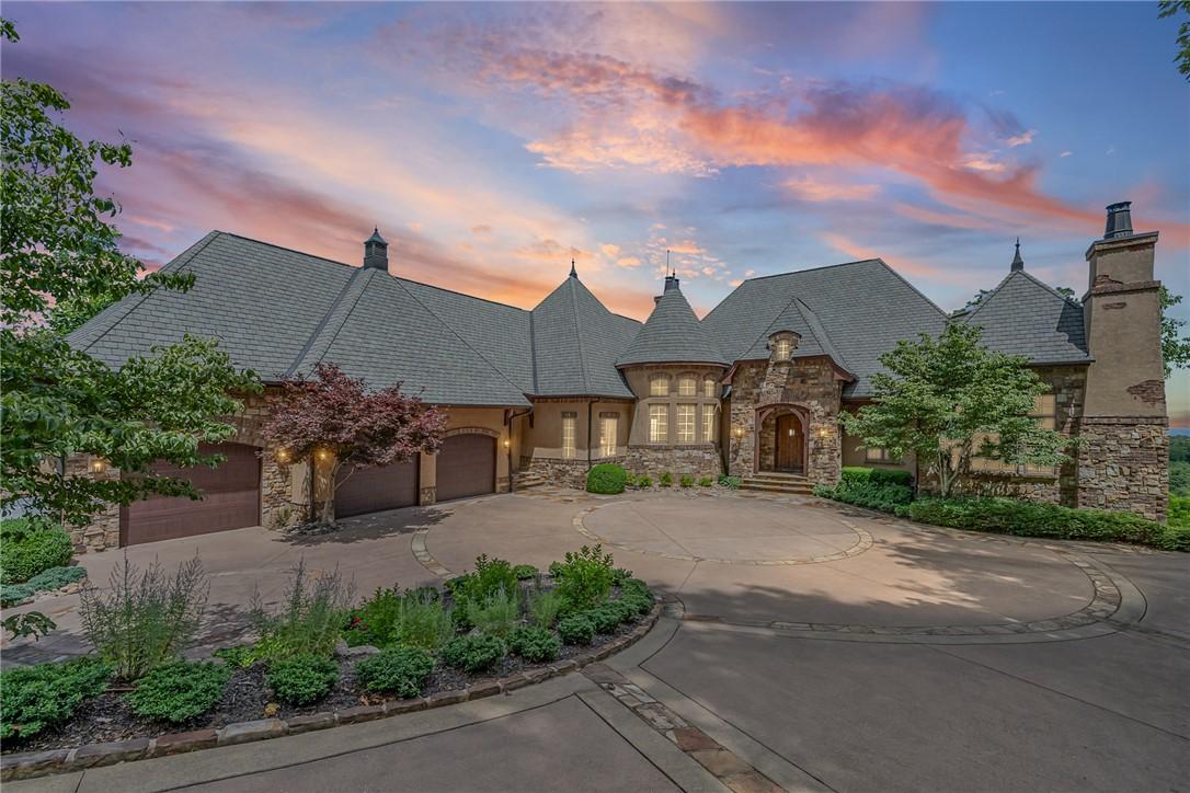 Image 2: A grand estate with a circular driveway and stone