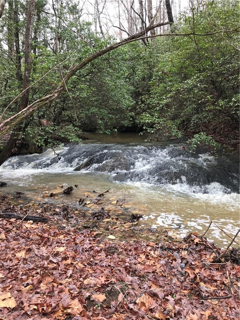 Image 1: Flowing creek spans the entire property and includ